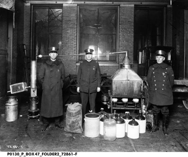 Indiana cops stand with illegal distillation equipment at the time during Prohibition.  Indiana Historical Society exhibition opening 