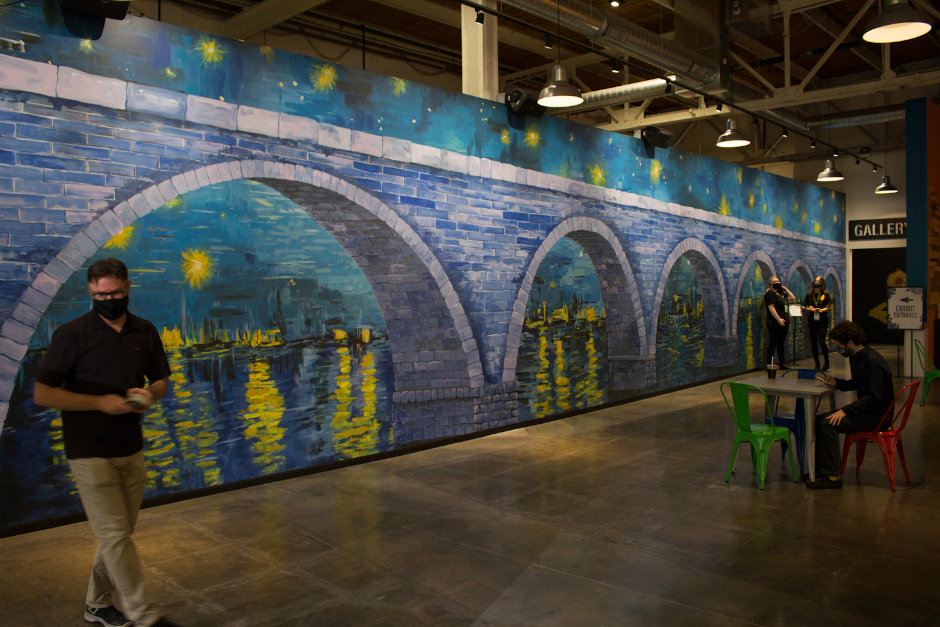 A mural with an arched stone bridge painted in a mysterious style reminiscent of Van Gogh